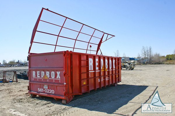 A red box container with a roof on top of it.
